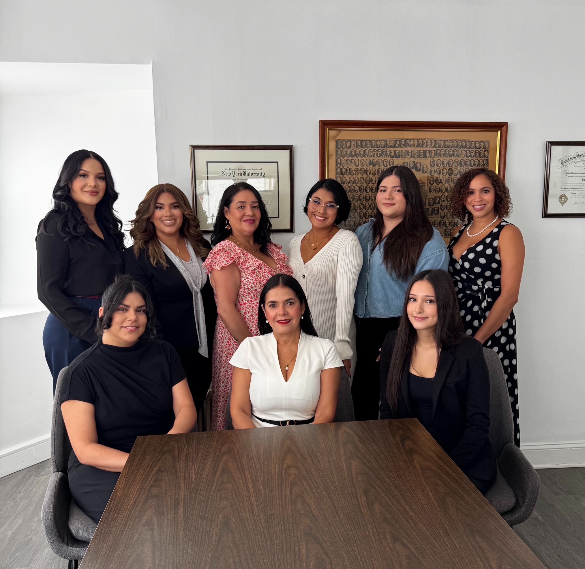 Raff & Raff staff: a group of nine women posed together in the firm's office below framed diplomas